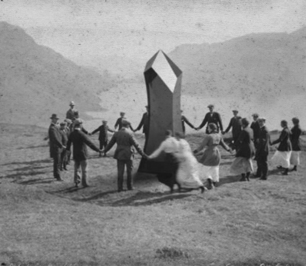 people dancing around a black monolith